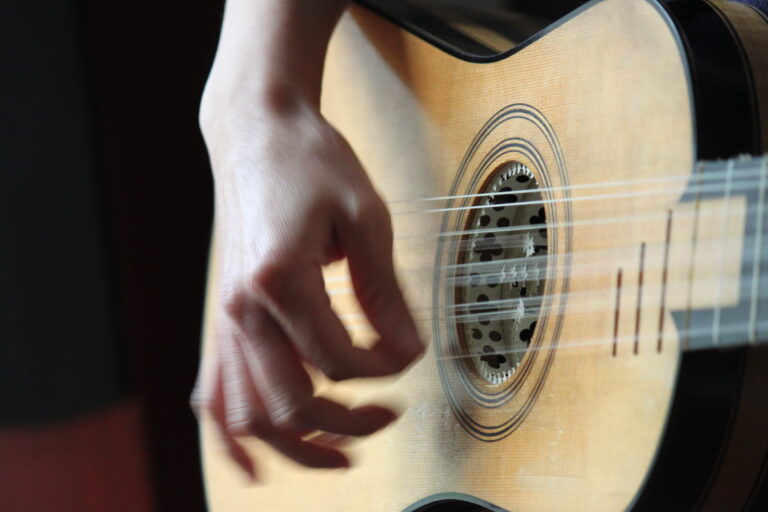main d'un musicien jouant sur une guitare